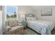 Comfortable bedroom with floral chair, a coastal themed bed, and a window with blinds at 668 Rycola Circle, Surfside Beach, SC 29575