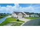 Scenic view of a home with a spacious driveway, well-kept lawn, and tranquil water feature nearby at 668 Rycola Circle, Surfside Beach, SC 29575