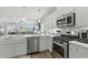 Bright kitchen featuring stainless steel appliances, white cabinetry, and a farmhouse sink at 668 Rycola Circle, Surfside Beach, SC 29575