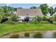 Aerial view of a home with a manicured lawn, patio area, and black metal fence near a pond at 700 Shell Point Ct., Longs, SC 29568