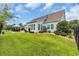 Landscaped backyard with a well-manicured lawn and a patio area for outdoor dining and relaxing at 700 Shell Point Ct., Longs, SC 29568