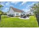 Well-maintained backyard featuring green grass, a concrete patio with outdoor furniture, and a black metal fence at 700 Shell Point Ct., Longs, SC 29568