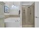 Bright bathroom with a glass-enclosed shower, soaking tub, and decorative lighting at 700 Shell Point Ct., Longs, SC 29568