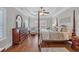 Spacious bedroom featuring four poster bed, tray ceiling, dresser, and hardwood floors at 700 Shell Point Ct., Longs, SC 29568