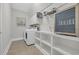 Laundry room features a washer, dryer, storage cabinets, shelving, and tile flooring at 700 Shell Point Ct., Longs, SC 29568
