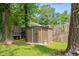 Backyard view showing a storage shed and a lawn bordered by trees and a wooden fence at 708 15Th Ave., Conway, SC 29526