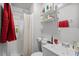 Bright bathroom with shower, toilet and sink, complemented by a mirror and well-lit shelving for storage at 708 15Th Ave., Conway, SC 29526