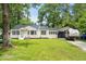 Charming single-story home with well-maintained lawn and a metal roof, surrounded by mature trees at 708 15Th Ave., Conway, SC 29526