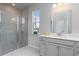Bright bathroom features a walk-in shower, large mirror, and modern vanity with a view to the outside at 7147 Shooting Star Way, Myrtle Beach, SC 29579