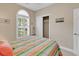 Well-lit bedroom with a window featuring shutter blinds, a closet, and a bed covered in a colorful striped quilt at 876 Palmetto Trail # 103, Myrtle Beach, SC 29577
