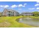 Well-maintained condo buildings sit around a picturesque pond with a fountain and green lawn at 876 Palmetto Trail # 103, Myrtle Beach, SC 29577
