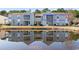 Condo exterior reflecting in the pond, highlighting a serene setting with lush landscaping at 8861 Chandler Dr. # F, Surfside Beach, SC 29575