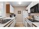 Efficient kitchen featuring white appliances, a black microwave, and a sink beneath a bright window at 8861 Chandler Dr. # F, Surfside Beach, SC 29575