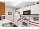 Efficient kitchen layout with white appliances and countertops, plus a stainless steel sink at 8861 Chandler Dr. # F, Surfside Beach, SC 29575