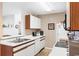Efficient kitchen with white cabinetry, appliances, sink, and a coffee-themed rug at 8861 Chandler Dr. # F, Surfside Beach, SC 29575