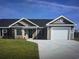 Charming single story home featuring tidy lawn, two car garage, and neutral siding under a blue sky at Tbb 2 St. John Rd., Galivants Ferry, SC 29544