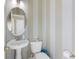 Powder room features a pedestal sink, round mirror and striped wallpaper at 100 Culpepper Way # 1003, Myrtle Beach, SC 29579