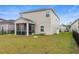 Exterior view of the home featuring a screened-in porch, a fenced-in yard, and a well-manicured lawn at 1078 Saltgrass Way, Myrtle Beach, SC 29588
