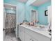 Bright bathroom features a double sink vanity, a view of the toilet, and a shower with blue walls at 1078 Saltgrass Way, Myrtle Beach, SC 29588