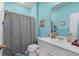 Bright bathroom features a single sink vanity, tub and shower combination, and blue painted walls at 1078 Saltgrass Way, Myrtle Beach, SC 29588