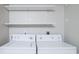 Functional laundry area includes a side-by-side washer and dryer set, with two floating shelves at 1125 Blue Stem Dr. # 29F, Pawleys Island, SC 29585