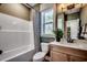 Modern bathroom with a shower-tub combo, patterned curtain, updated vanity, and bright natural lighting at 115 Northbrook Dr, Murrells Inlet, SC 29576