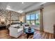 Sunlit bedroom with a four-poster bed, hardwood floors, and a seating area near the large window at 115 Northbrook Dr, Murrells Inlet, SC 29576