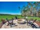 Outdoor fire pit area surrounded by chairs, mature trees, and views of the green golf course at 115 Northbrook Dr, Murrells Inlet, SC 29576