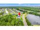 Wide aerial view of a home near a lake and surrounded by lush green trees at 116 Sago Palm Dr., Myrtle Beach, SC 29579