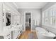Elegant bathroom with double sinks, soaking tub, walk-in closet, and abundant natural light from a large window at 116 Sago Palm Dr., Myrtle Beach, SC 29579