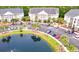 Condominium complex featuring lush landscaping with a large pond and ample parking for residents and guests at 118 Birch N Coppice Dr. # 6, Surfside Beach, SC 29575