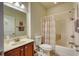 Bathroom with a single sink vanity, a toilet, and a shower-tub combination with a striped curtain at 118 Birch N Coppice Dr. # 6, Surfside Beach, SC 29575