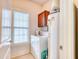 Functional laundry room features a washer, dryer, storage cabinet, and a bright window for ventilation at 118 Birch N Coppice Dr. # 6, Surfside Beach, SC 29575