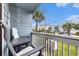 Balcony with outdoor seating, offering a relaxing view of the community's palm-lined streets and manicured lawns at 1210 N Ocean Blvd. # 104, Surfside Beach, SC 29575