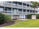 Exterior view of the Surfside by the Sea building, showcasing multiple balconies and well-maintained landscaping at 1210 N Ocean Blvd. # 104, Surfside Beach, SC 29575