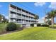 Charming multifamily unit featuring multiple balconies with white railings and lush landscaping at 1210 N Ocean Blvd. # 104, Surfside Beach, SC 29575