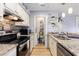 Modern kitchen with granite countertops, stainless steel appliances, and convenient laundry access at 1210 N Ocean Blvd. # 104, Surfside Beach, SC 29575