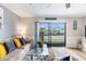 Cozy living room featuring a plush sectional couch, glass coffee table, and access to a balcony at 1210 N Ocean Blvd. # 104, Surfside Beach, SC 29575