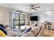 Bright living room with a plush sofa, glass coffee table, ceiling fan, and balcony access at 1210 N Ocean Blvd. # 104, Surfside Beach, SC 29575