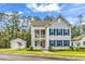 Charming two-story home featuring a double porch, gray siding, blue shutters, and a detached two-car garage at 1216 Newell Dr, Myrtle Beach, SC 29588