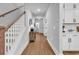 Inviting hallway with wood floors, white trim, and a view of a vanity with round mirror at 1216 Newell Dr, Myrtle Beach, SC 29588