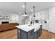 Open concept kitchen with an island and sink overlooking the living room area, and adjacent staircase at 1216 Newell Dr, Myrtle Beach, SC 29588