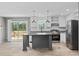 Modern kitchen with stainless steel appliances, gray island, white cabinetry, and sliding glass doors to the outside deck at 1301 Rabbit Ln., Conway, SC 29526