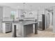 Well-lit kitchen featuring white cabinets, stainless steel appliances, grey island, and wood flooring throughout at 1301 Rabbit Ln., Conway, SC 29526