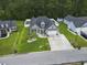 Aerial view of a charming home with a well-manicured lawn, lush landscaping, an attached garage, and a private backyard at 144 Baylee Circle, Aynor, SC 29544