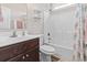 Bright bathroom featuring a shower-tub combo with decorative curtain, a toilet, and vanity at 144 Baylee Circle, Aynor, SC 29544
