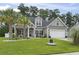 Inviting home featuring a well-manicured lawn, lush landscaping, charming curb appeal, and an attached garage at 144 Baylee Circle, Aynor, SC 29544