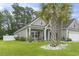 Charming single-Gathering home featuring a well-manicured lawn, lush landscaping, and attractive curb appeal with palm trees at 144 Baylee Circle, Aynor, SC 29544