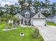 Charming home featuring manicured lawn, palm trees, rock garden, and an attached two-car garage at 144 Baylee Circle, Aynor, SC 29544