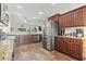 Open-concept kitchen features dark wood cabinets, stainless steel refrigerator, and granite countertops at 144 Baylee Circle, Aynor, SC 29544
